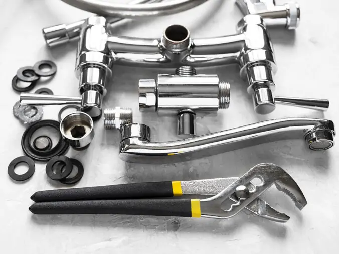 stainless plumbing fittings and a wrench